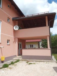 a pink house with a balcony on the side at Apartment LIKA in Gospić