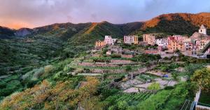 a village on top of a hill with mountains at Arbanella in Corniglia