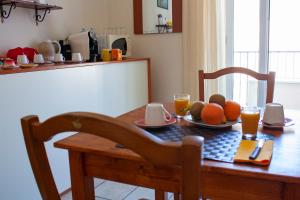stół z talerzem owoców i dwie szklanki soku pomarańczowego w obiekcie Poseidon Alghero w mieście Alghero