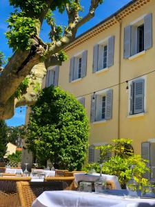 une table devant un bâtiment avec des tables blanches dans l'établissement Hôtel du Parc, à Draguignan