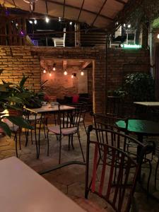 a restaurant with tables and chairs and a brick wall at Bed and Breakfast "Caffe-caffe" in Kikinda