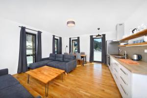kuchnia i salon z kanapą i stołem w obiekcie Podstata Apartments Vrchlabí - Rotterovka w Vrchlabi