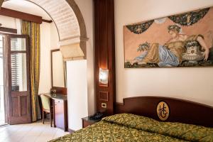 1 dormitorio con 1 cama y una pintura en la pared en Hotel Garibaldi, en Milazzo