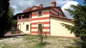 una casa con rayas rojas y blancas. en Poggio di Villa Fano, en Citerna