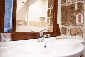 W łazience znajduje się umywalka i lustro. w obiekcie Poseidon Alghero w mieście Alghero
