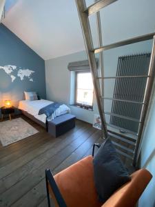 een slaapkamer met een bed en een bank in een kamer bij LE REFUGE D'ELI - La Maison in Vitrival