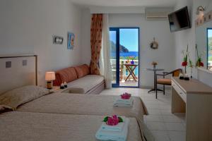a bedroom with two beds and a view of the ocean at Hotel Porto Koufo in Porto Koufo