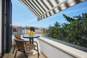 a table and two chairs on a balcony with a view at Apartments Nika in Turanj