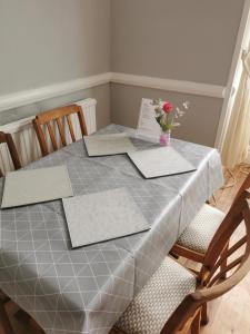 a dining room table with a table cloth and a vase of flowers at Leeds House Guest House in Bridlington