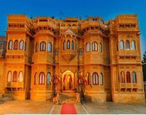 ein großes Backsteingebäude mit einer Treppe davor in der Unterkunft Hotel Lal Garh Fort And Palace in Jaisalmer