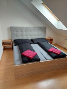 - un lit avec des oreillers noirs et rouges dans l'établissement Lagúna ubytovanie, à Nemšová