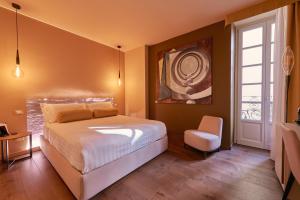 a bedroom with a bed and a chair and a window at 73 Boutique Hotel in Como