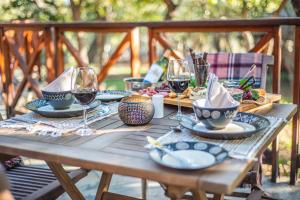 a wooden table with plates and glasses of wine at Dinkweng Safari Lodge in The Waterberg Biosphere