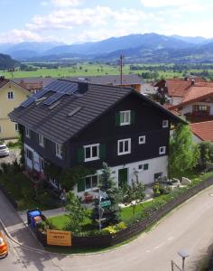 a black and white house with solar panels on it at Haus Marienfried in Rettenberg