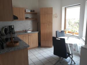 a kitchen with a table and a window and a table at Mosel-Ferienwohnung Berhard in Bruttig-Fankel