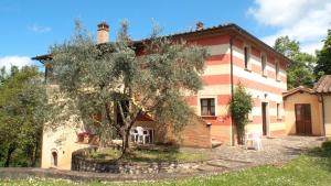 una casa con un árbol delante de ella en Poggio di Villa Fano, en Citerna