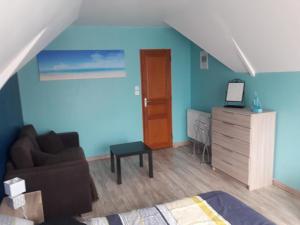 ein Wohnzimmer mit einem Sofa und einer Kommode in der Unterkunft Au fil de l'Eau in Saulzoir