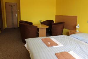 pokój hotelowy z łóżkiem, stołem i krzesłami w obiekcie Hotel M w Jesioniku
