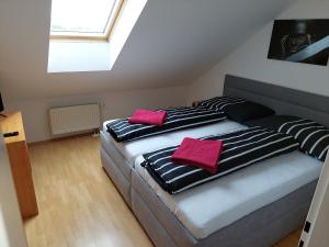 - 2 lits dans une chambre avec 2 oreillers roses dans l'établissement Lagúna ubytovanie, à Nemšová