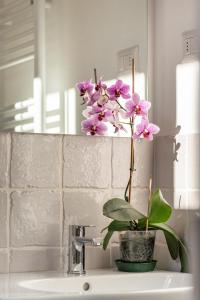 lavabo con jarrón con flores púrpura en Villa Galgani, en Lucca
