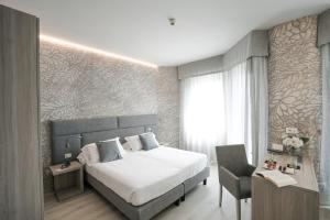 a bedroom with a large bed and a chair at Sole Mare in Ventimiglia