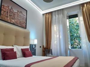 um quarto com uma cama com almofadas vermelhas e uma janela em Aventino Guest House em Roma