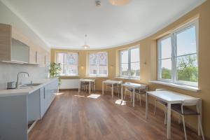 a large kitchen with tables and chairs and windows at Freedom Hostel in Kraków