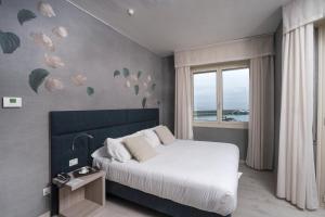 a bedroom with a white bed and a window at Sole Mare in Ventimiglia