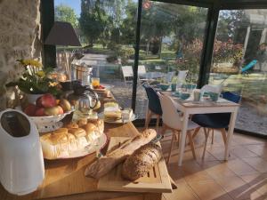 a table with bread and pastries on it in a room at Les fleurs du Mont in Céaux