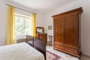 Schlafzimmer mit einem Bett und einem Holzschrank in der Unterkunft At Armando's Home in Zafferana Etnea