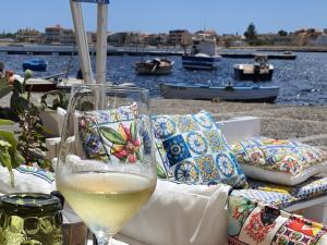 ein Glas Wein auf einem Tisch in der Nähe des Wassers in der Unterkunft Amareilmare2 in Marzamemi