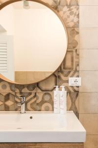 ein Bad mit einem Waschbecken und einem Spiegel in der Unterkunft Marina Suite by Wonderful Italy in Palermo