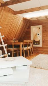 a dining room with a table and wooden walls at DOM LAS - natura, relaks, jacuzzi. in Mianów +21 photos