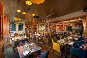 un ristorante con tavoli e sedie in una stanza di Queens Hotel a Ennis Altre 23 foto