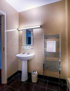 bagno con lavandino e specchio di Queens Hotel a Ennis