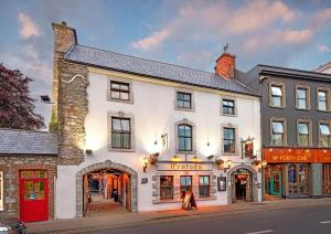 un edificio blanco en la esquina de una calle en Queens Hotel, en Ennis