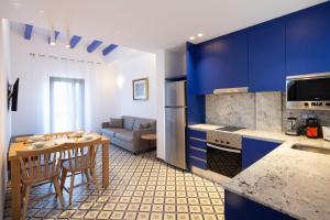 a kitchen with blue cabinets and a table with chairs at Tgna Cervantes 8 in Tarragona
