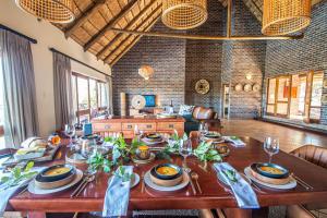 a dining room with a table with plates and wine glasses at Dinkweng Safari Lodge in The Waterberg Biosphere