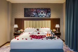 a large white bed with red roses on it at Art View Hotel - Riyadh Convention & Exhibition Center in Riyadh +43 photos