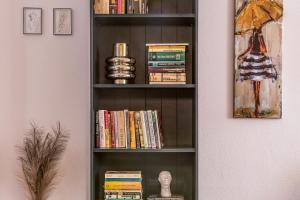 POETIKA apartments في بريشوف: رف للكتب مليء بالكتب بجوار جدار