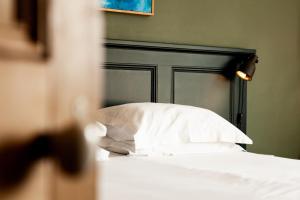 - un lit avec une tête de lit noire et des oreillers blancs dans l'établissement The Old Vicarage, à Cardigan