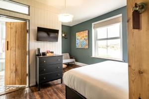 a bedroom with a bed and a dresser and a window at The Old Vicarage in Cardigan