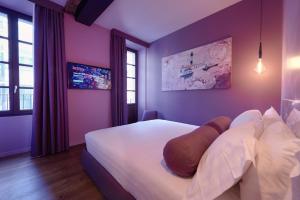 a bedroom with purple walls and a bed with pillows at 73 Boutique Hotel in Como