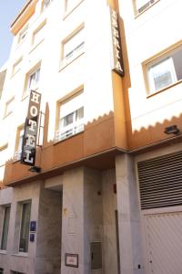 a building with a sign on the side of it at Hotel Iberia Plaza América in Cáceres