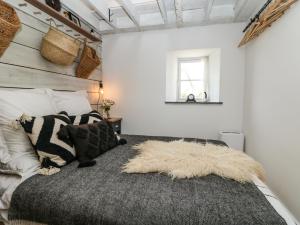 a bedroom with a large bed with a blanket at Rocket Cart House in Landewednack