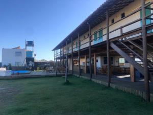 un edificio con un patio de césped junto a un edificio con escaleras en Pousada Porto Taipus en Marau