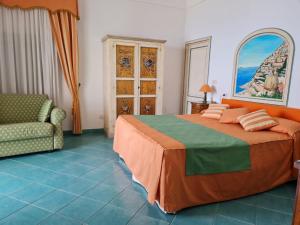 a bedroom with a bed and a couch and a chair at Casa Teresa in Positano