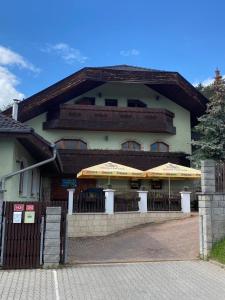 a building with tables and umbrellas in front of it at Penzion pod lesem in Most