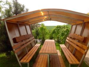 a picnic table with awning and benches in a garden at Usadba 12 Stulev in Tarasovo