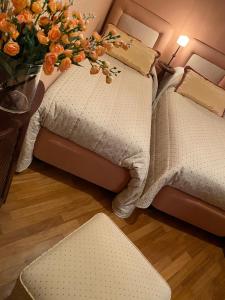 a room with two beds and a vase of flowers at IL RIFUGIO DI LYLLA PESCOCOSTANZO in Pescocostanzo